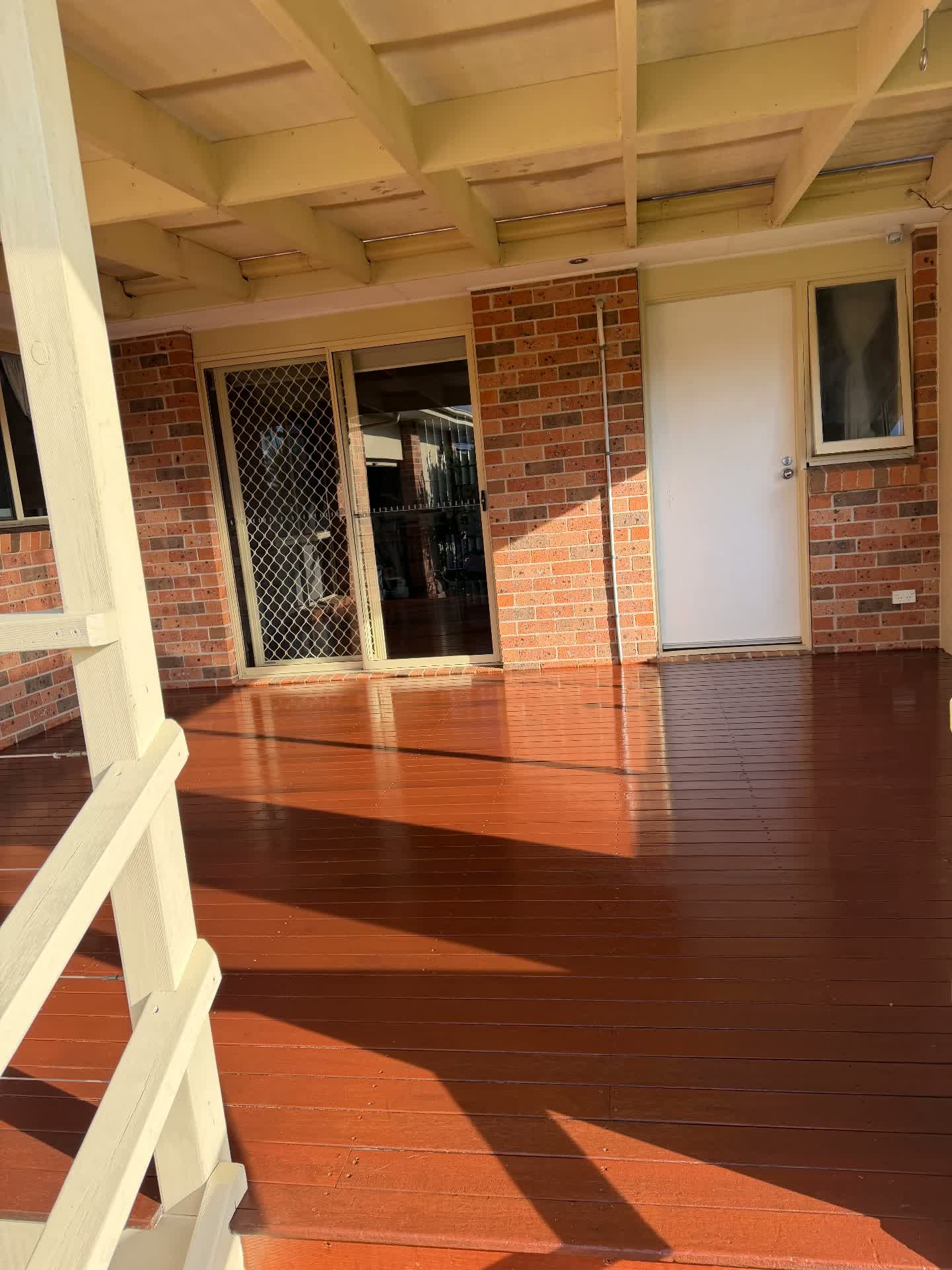 Covered verandah decking sealed in a rich red stain